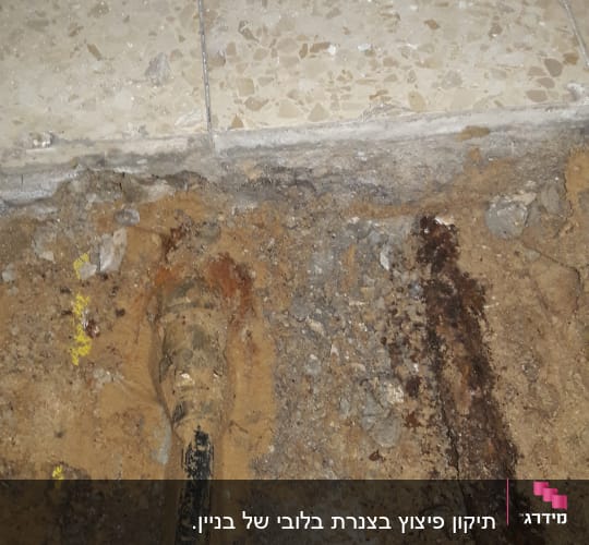 צינור מתכת חלוד באדמה ליד רצפה